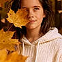 child, girl, autumn, fall_leaves, leaf, outdoor, nature, portrait, freckles, hoodie, sweater, brown_hair, forest, seasonal, young_person, casual_clothing, warm_colors, closeup, thinking, daylight