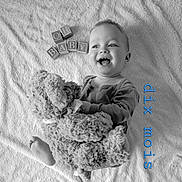 Victor a rejoint le concours — aidez-le/la à gagner de superbes lots ! baby, teddy_bear, blocks, blanket, smiling, infant, toy, black_and_white, happy, child, soft_texture, clothing, portrait, lying_down, cute, playful, young_child, monochrome, expression, feet