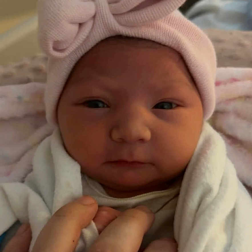 Dallas is registered to the contest to win money with this photo: architecture, baby, blanket, bodypart, bonnet, building, cap, clothing, face, finger, glove, hand, hat, head, hospital, newborn, person, photography, portrait, scarf