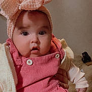Antonella participe au concours pour gagner de l'argent avec cette photo : baby, infant, headband, bow, pink_overalls, corduroy, buttons, jacket, hand, wide_eyes, cheeks, open_mouth, portrait, indoor, bed, blanket, purse, neutral_wall, cute, child