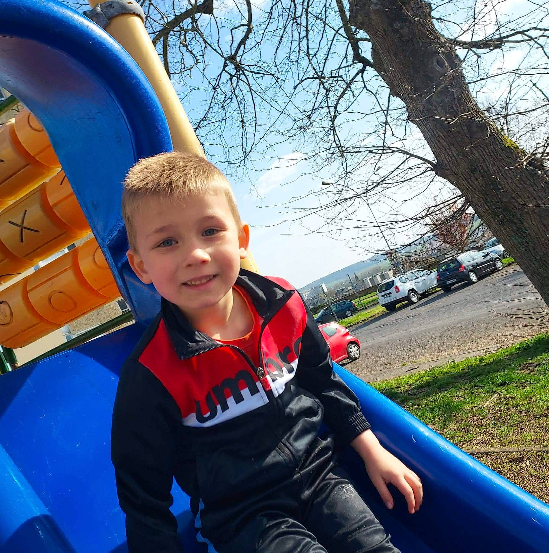 Kylian a rejoint le concours — aidez-le/la à gagner de superbes lots ! automotive_exterior, blue, city, electric_blue, fun, grass, happy, joy, leisure, motor_vehicle, person, plant, playground, product, public_space, recreation, sky, snapshot, t_shirt, toddler