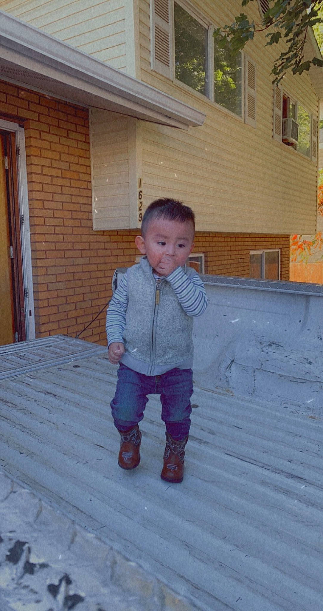 Elíseo is registered to the contest to win money with this photo: baby_toddler_clothing, child, denim, door, eye, flooring, fun, grass, hardwood, house, jacket, pattern, person, road_surface, roof, siding, toddler, tree, window, winter