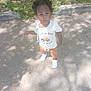 Ezra is registered to the contest to win money with this photo: toddler, child, outdoor, grass, concrete, shirt, sneakers, curly_hair, expression, sunlight, shadow, nature, sidewalk, young_child, casual_clothing, person, standing, daylight, cute, curious
