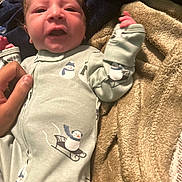 Ario joined the competition — help win amazing prizes! newborn, baby, infant, child, portrait, lying_down, blanket, cozy, pajamas, penguin, winter, mittens, hand, adult_hand, face, indoors, close_up, sleepy, cute, textile