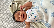 Julietta is registered to the contest to win money with this photo: animal_pattern, baby, bedspread, blanket, blue, child, cozy, cute, face, happy, infant, lying_down, onesie, pattern, raised_hands, skin, sleepwear, smiling, toddler, white