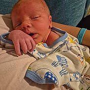 Bentley is registered to the contest to win money with this photo: newborn, baby, infant, sleeping, onesie, hand, face, closeup, soft, resting, cozy, person, cute, skin, clothing, fabric, comfort, indoors, portrait, child