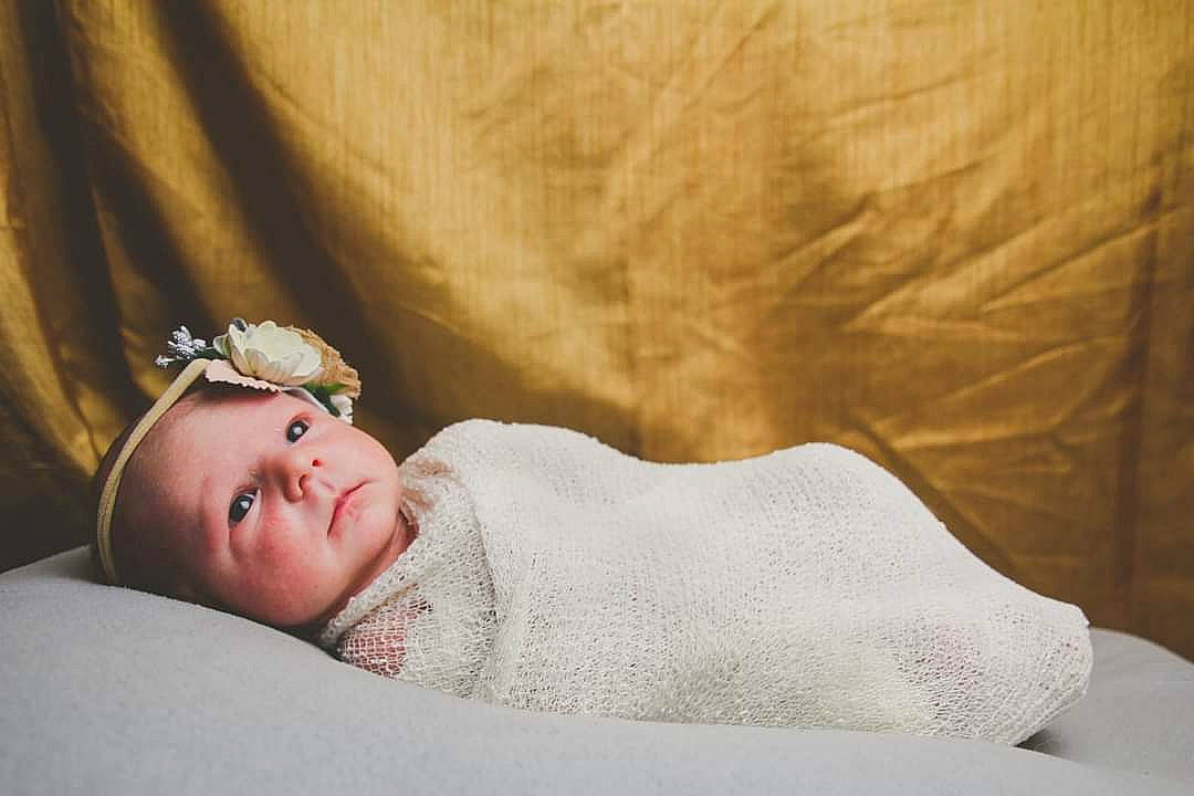 Reya joined the competition — help win amazing prizes! arm, baby, baby_sleeping, baby_toddler_clothing, comfort, dress, event, eye, eyelash, flash_photography, flooring, happy, headpiece, human_body, linens, lip, person, sitting, smile, textile