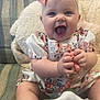 Sadie joined the competition — help win amazing prizes! baby, child, smiling, bow, pink_bow, dress, floral_dress, toy, beads, couch, pillow, indoor, happy, infant, cute, hands, sitting, face, person, portrait