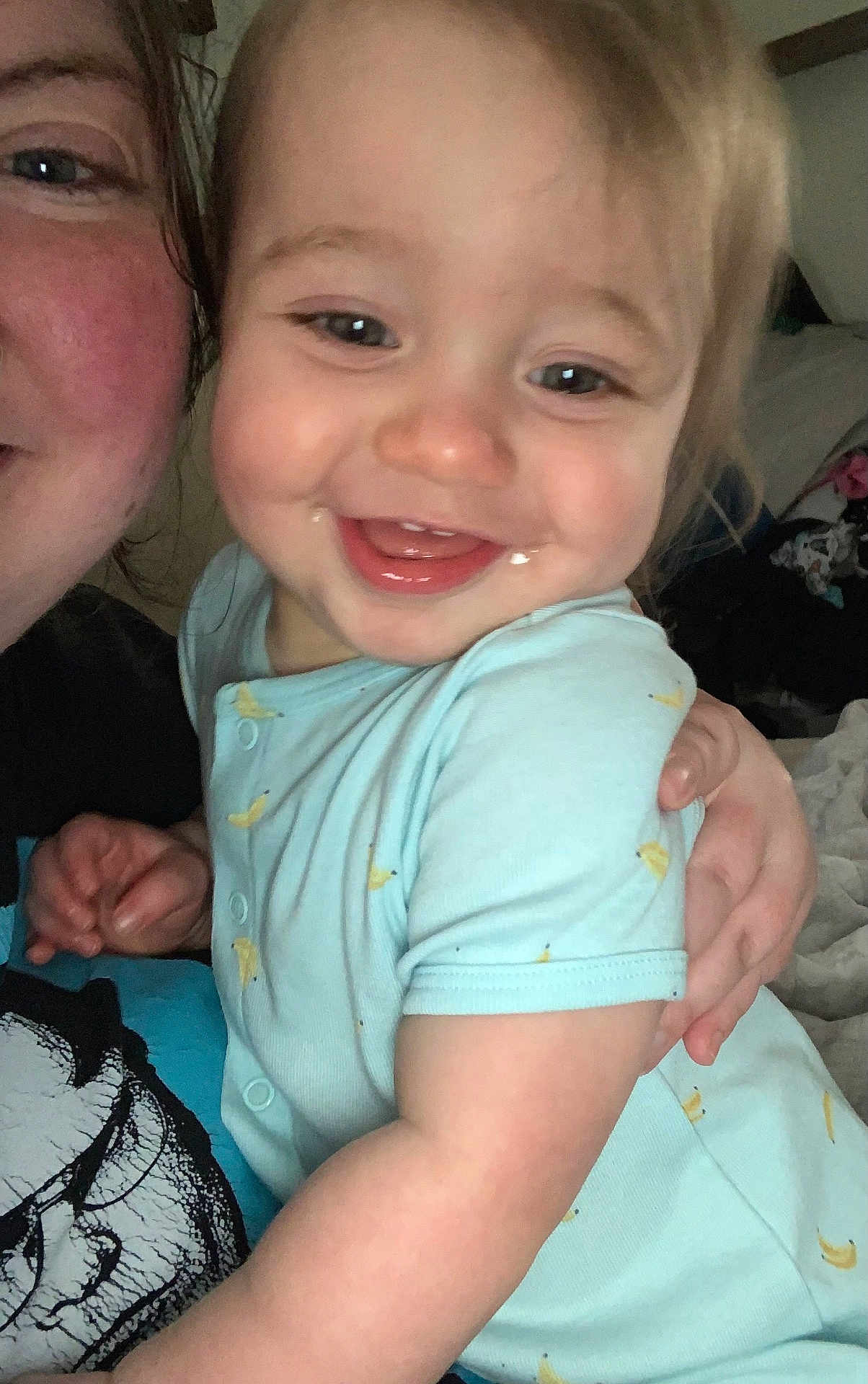 Declan joined the competition — help win amazing prizes! toddler, child, smile, face, person, hug, blue_clothing, indoor, happy, baby, onesie, light_skin, adult, hand, room, casual, closeup, expression, infant, cozy