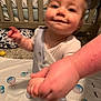 Declan joined the competition — help win amazing prizes! toddler, child, baby, holding_hand, smile, indoor, crib, bed, blanket, person, carpet, footwear, hand, adult, playmat, toy, happy, blur, support, family