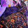 cat, kitten, pet, blanket, quilt, bedding, sleeping, nap, paw, fur, bed, indoor, cozy, purple_light, pattern, flowers, skeleton, halloween, close_up, relaxing