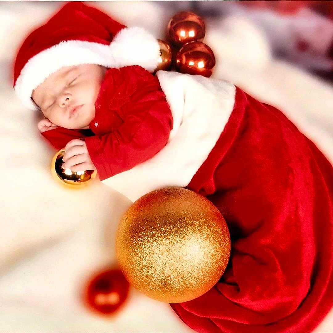 Ydalia participe au concours pour gagner de l'argent avec cette photo : baby, blanket, celebration, child, christmas, christmas_ornaments, cozy, cute, festive, festivity, gold_ball, holiday, holiday_season, infant, peaceful, portrait, red_clothing, santa_hat, sleeping, soft_texture
