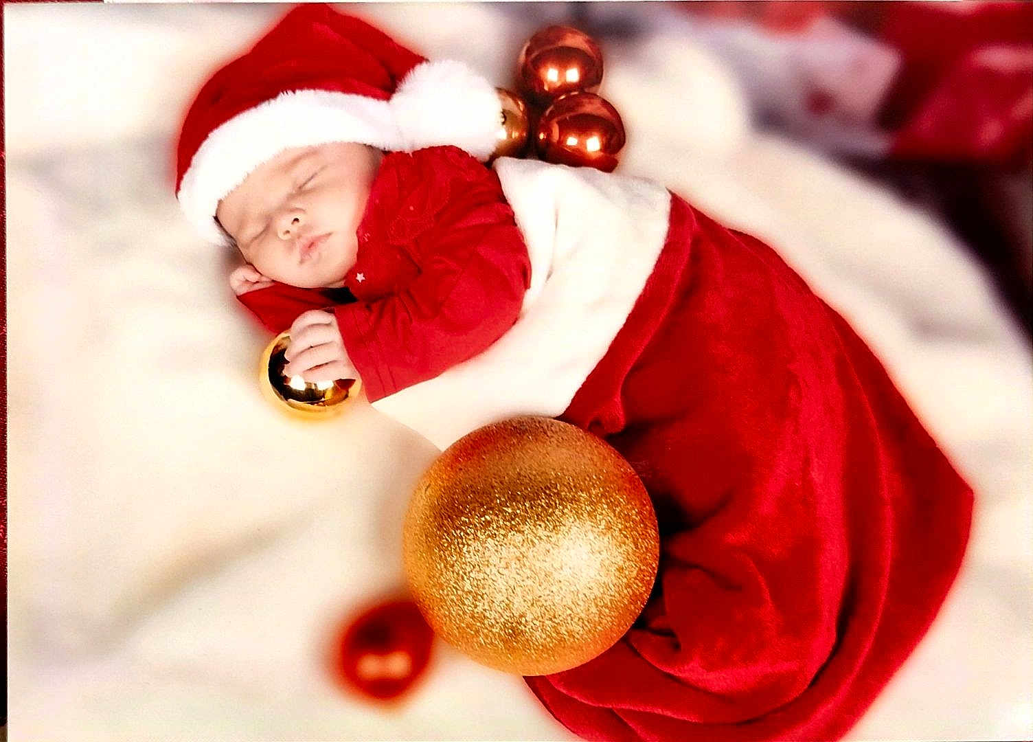 Ydalia participe au concours pour gagner de l'argent avec cette photo : baby, sleeping, santa_hat, red_clothing, christmas_ornaments, gold_ball, holiday, festive, blanket, cute, infant, holiday_season, soft_texture, peaceful, child, portrait, celebration, cozy, christmas, festivity