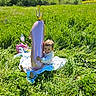Mya participe au concours pour gagner de l'argent avec cette photo : balloon, blanket, casual_clothing, child, crown, cute, daytime, field, grass, greenery, happy, nature, number_one, outdoor, playtime, sunny, toddler, toy, unicorn_toy, water_bottle