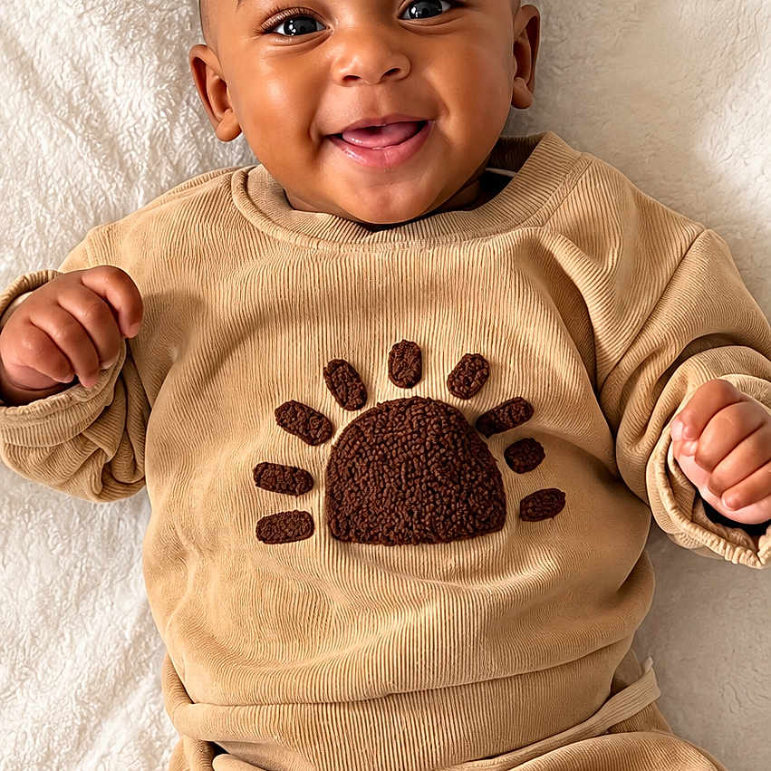 Mason joined the competition — help win amazing prizes! baby, child, infant, smiling, happy, portrait, lying_down, blanket, indoor, clothing, tan_outfit, hedgehog_design, long_sleeves, pajamas, face, eyes, hands, soft_texture, cozy, photography