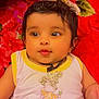Avinaaz is registered to the contest to win money with this photo: baby, bear_print, blanket, child, clothing, colorful, cute, eyes, face, floral_pattern, hair, indoors, infant, lying_down, necklace, person, skin, sleeveless_top, smile, young_child