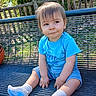 toddler, child, bench, outdoor, daylight, blue_shirt, denim_shorts, socks, basketball, park, fence, greenery, grass, wooden_rail, playful, curious, person, casual_clothing, sitting, smile