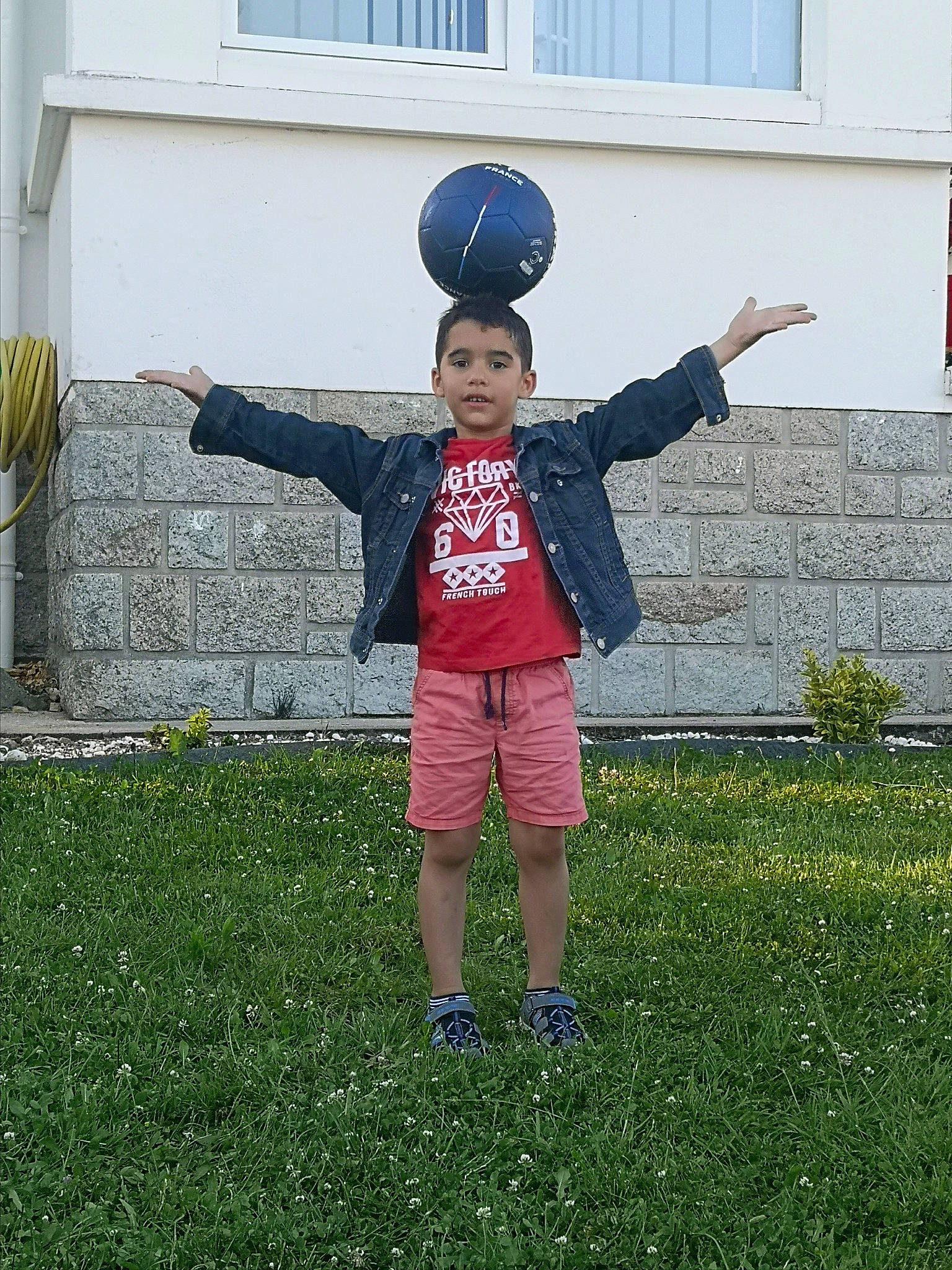 Jonathan participe au concours pour gagner de l'argent avec cette photo : ball, blue, electric_blue, face, fun, gesture, grass, happy, lawn, leisure, people_in_nature, person, plant, player, shorts, sports_equipment, sports_gear, standing, t_shirt, toddler