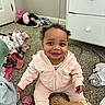 baby, child, pink_outfit, carpet, hairbrush, clothes, smile, indoor, baby_accessory, pacifier, furniture, drawer, room, electric_outlet, happy, cute, sitting, child_playing, person, portrait