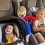 Liam participe au concours pour gagner de l'argent avec cette photo : baby, car_seat, child, curtain, cute, family, happy, indoor, infant, knitted_doll, person, playful, seat, seatbelt, smile, toddler, toy, white_dress, window, yellow_overalls