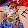 baby, infant, pacifier, plush_toy, elephant_toy, blanket, blue_blanket, striped_onesie, cushion, hello_kitty, child, indoor, resting, sleepy, soft_toy, comfort, cute, closeup, fabric, hand
