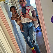 Isiah is registered to the contest to win money with this photo: woman, baby, mirror, selfie, jeans, ripped_jeans, sneakers, yellow_socks, phone, earrings, tattoos, indoor, window, door, floor, handbag, holding, reflection, casual_clothing, person