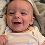 Weston is registered to the contest to win money with this photo: baby, smiling, infant, blanket, clothing, white, onesie, nike, happy, face, skin, hand, portrait, cute, cozy, child, young, indoors, person, closeup