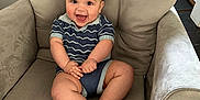 Kaiser is registered to the contest to win money with this photo: baby, child, smiling, armchair, indoor, clothing, happy, cute, person, furniture, seated, legs, face, skin, head, infant, room, comfort, blue, striped
