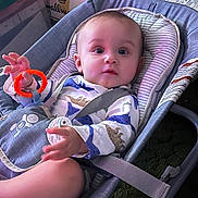 Oaklee joined the competition — help win amazing prizes! baby, baby_seat, blue_eyes, cardboard_boxes, carseat, child, curious_expression, dinosaur_print, fabric_padding, household, indoor, infant, onesie, person, plastic_frame, short_hair, sitting, straps, teething_ring, toy