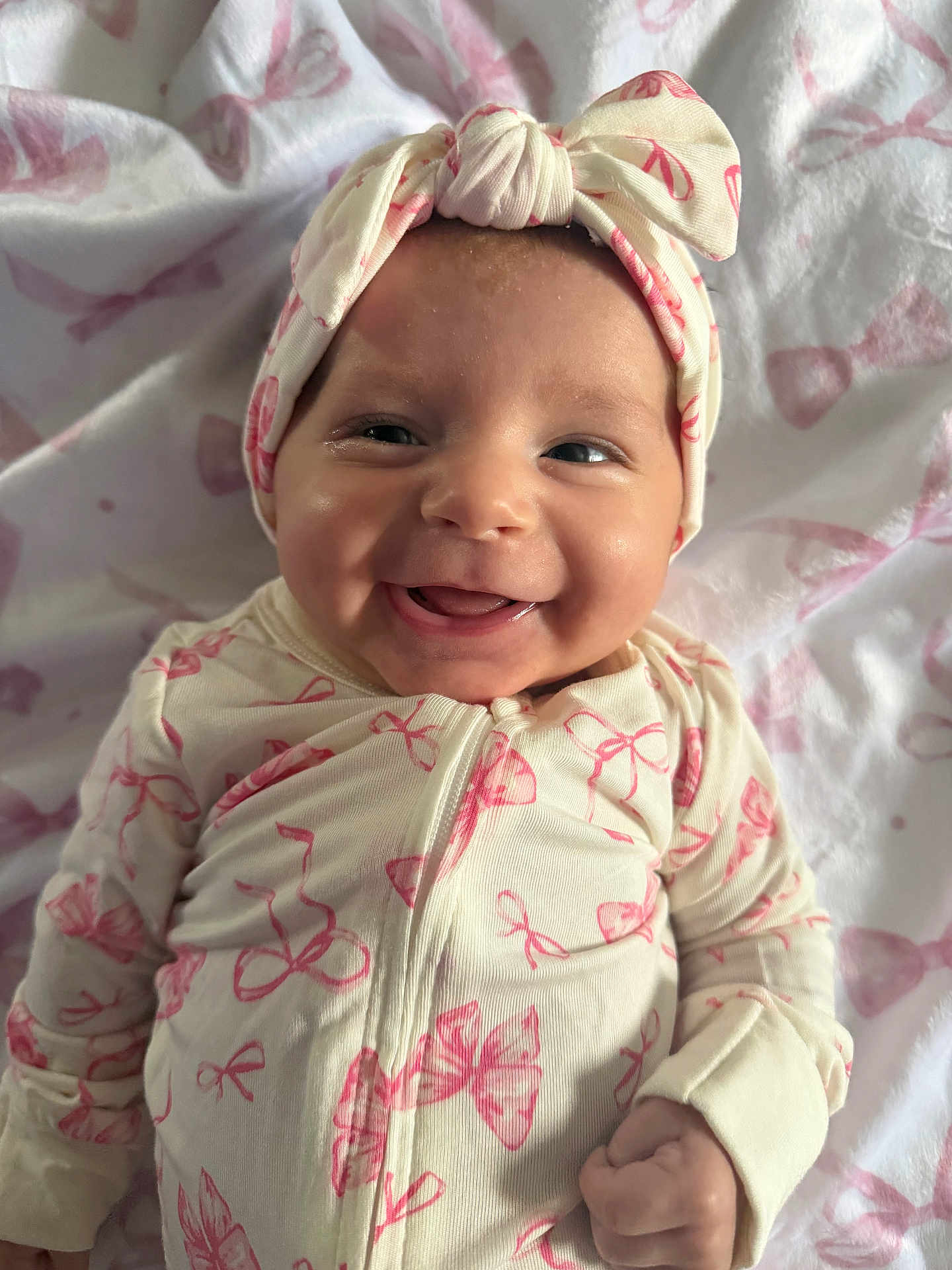 Magnolia joined the competition — help win amazing prizes! baby, infant, smiling, face, headband, bow, onesie, blanket, pink, pattern_bows, newborn, close_up, portrait, lying_down, happy, cheeks, cute, hand, soft_texture, sleepwear