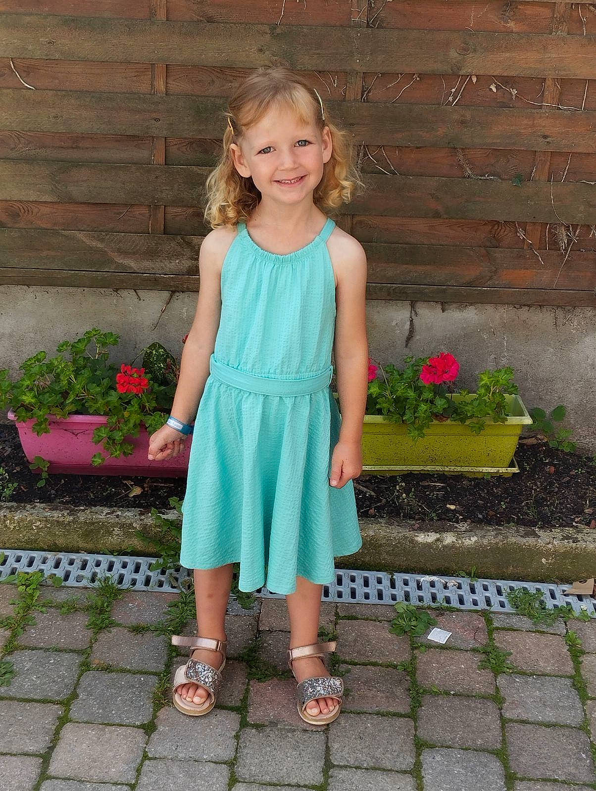 Noëly a rejoint le concours — aidez-le/la à gagner de superbes lots ! blond, day_dress, dress, electric_blue, flower, flowerpot, grass, happy, houseplant, human_leg, joy, leisure, magenta, pattern, person, petal, pink, plant, sandal, shoe