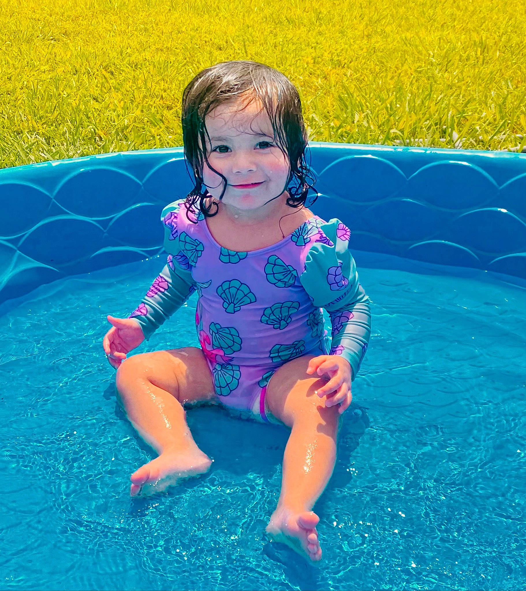 Anais is registered to the contest to win money with this photo: azure, baby_toddler_clothing, blue, fun, grass, green, hair, happy, head, human_body, joy, leg, leisure, people_in_nature, person, plant, smile, summer, sunlight, thigh