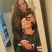 Mathis participe au concours pour gagner de l'argent avec cette photo : mirror_selfie, woman, child, smile, indoor, phone, reflection, casual_clothing, long_hair, young_boy, home, mirror, happy, portrait, family, hand, nail_polish, room, door, wall_art