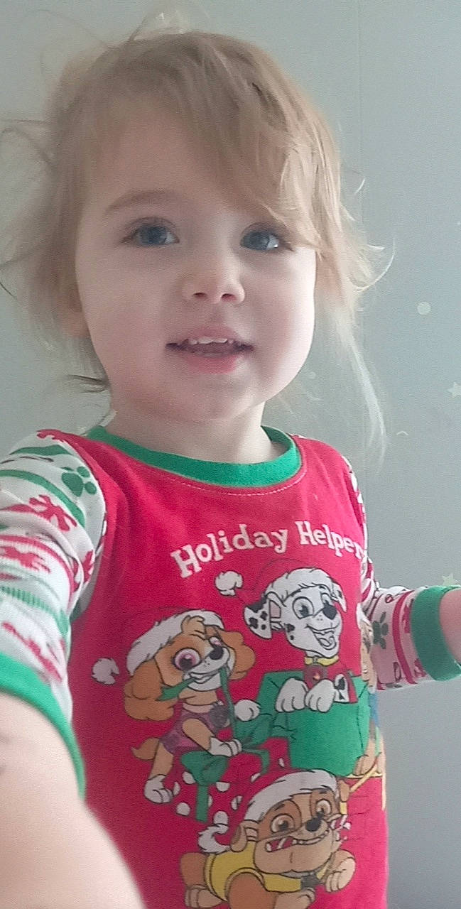 Casper is registered to the contest to win money with this photo: baby_toddler_clothing, cheek, eyelash, face, facial_expression, happy, head, human_body, lip, neck, nose, organ, person, red, skin, sleeve, smile, standing, t_shirt, toddler