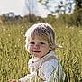 baby, blonde, countryside, face, field, flower, grass, grassland, hair, happy, head, meadow, nature, outdoors, person, photography, plant, portrait, rural, smile