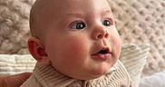 Swann participe au concours pour gagner de l'argent avec cette photo : baby, bald_head, blanket, button, cheeks, child, close_up, clothing, corduroy, couch, ear, eyes, gaze, indoor, infant, mouth_open, nose, portrait, skin, textured_background