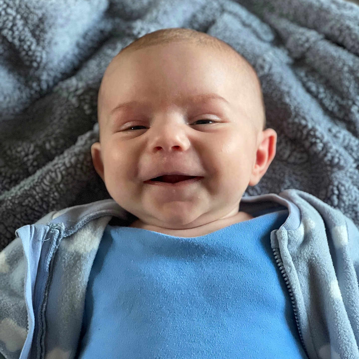 Tommy is registered to the contest to win money with this photo: baby, babylaughing, blanket, face, happy, head, laughing, newborn, person, photography, portrait, quilt, smile, towel