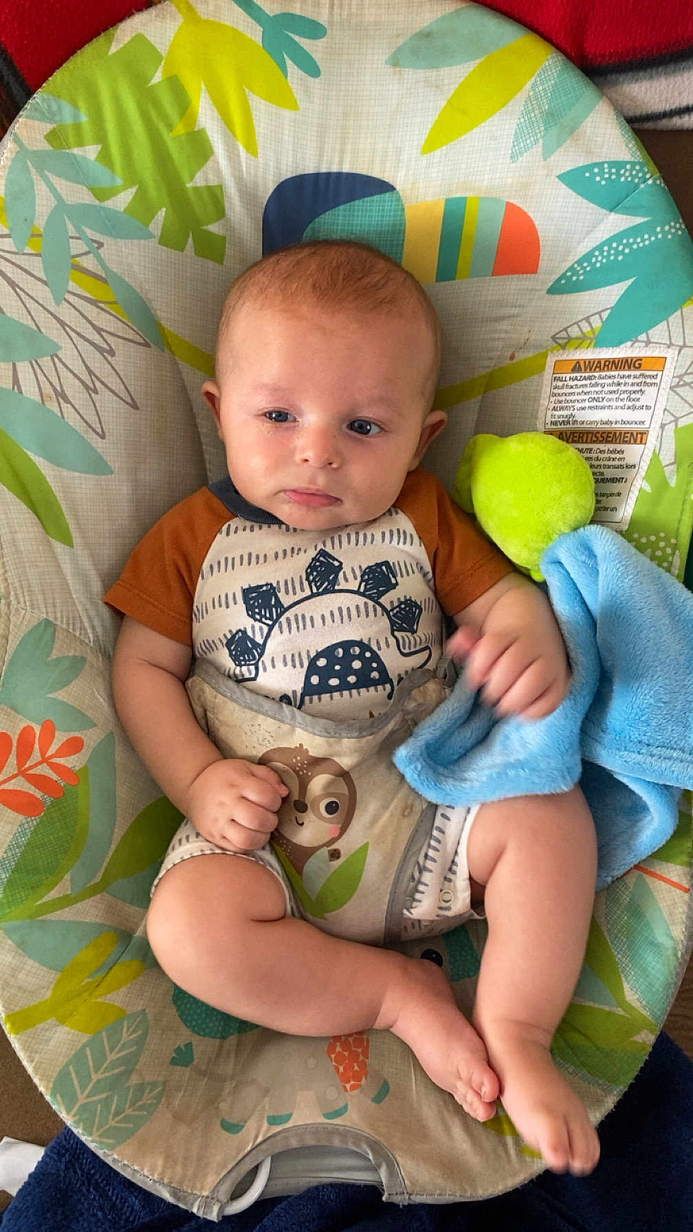 Shiloh is registered to the contest to win money with this photo: baby, infant, child, baby_seat, blanket, soft_toy, clothing, pattern, leafy_design, cute, skin, face, legs, feet, hand, comfort, indoors, colorful, expression, pout