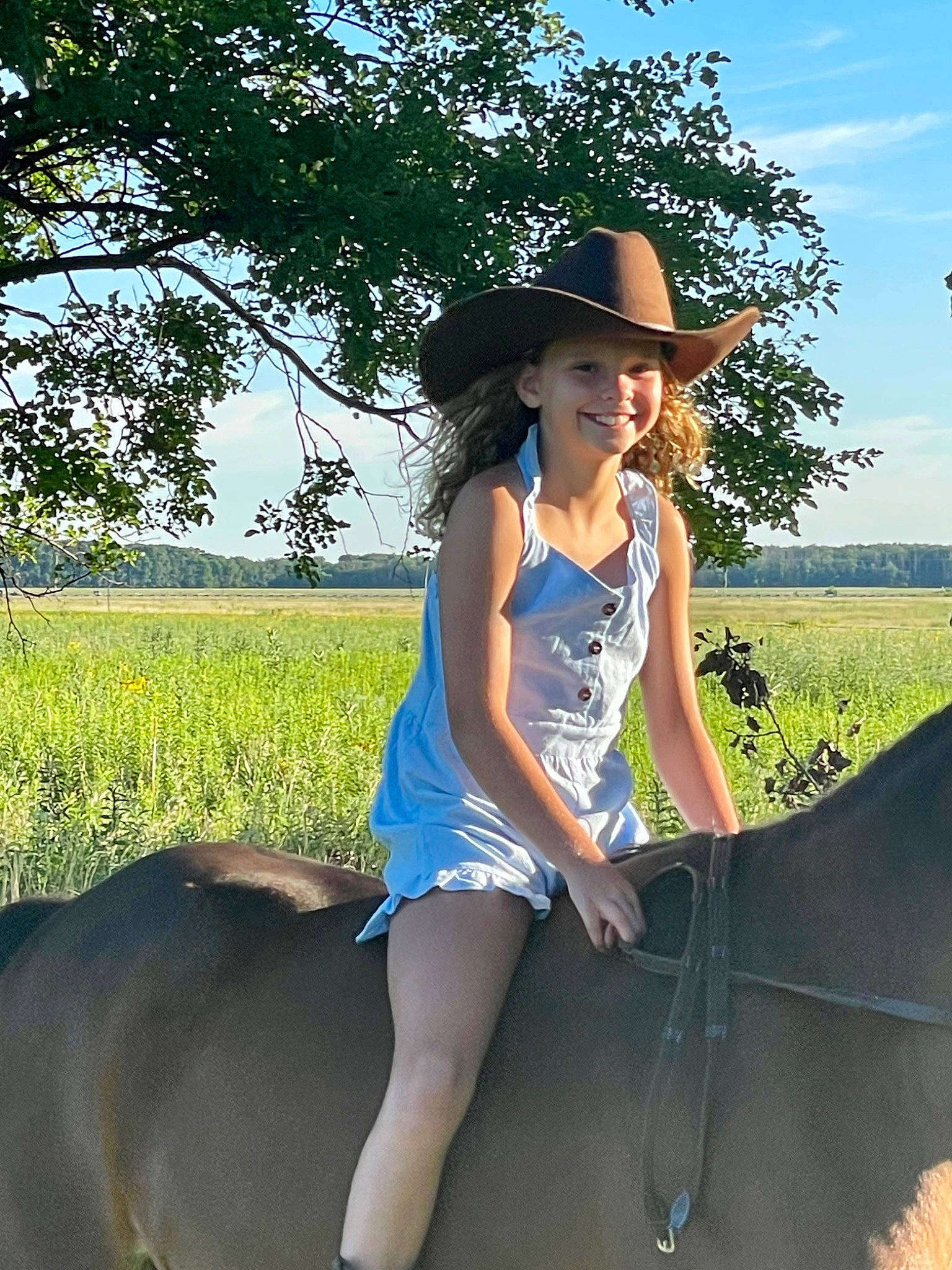 Teagan is registered to the contest to win money with this photo: cool, dress, eyewear, grass, grassland, happy, hat, headgear, headwear, joy, leisure, mammal, people_in_nature, person, plant, sky, smile, sun_hat, sunglasses, travel