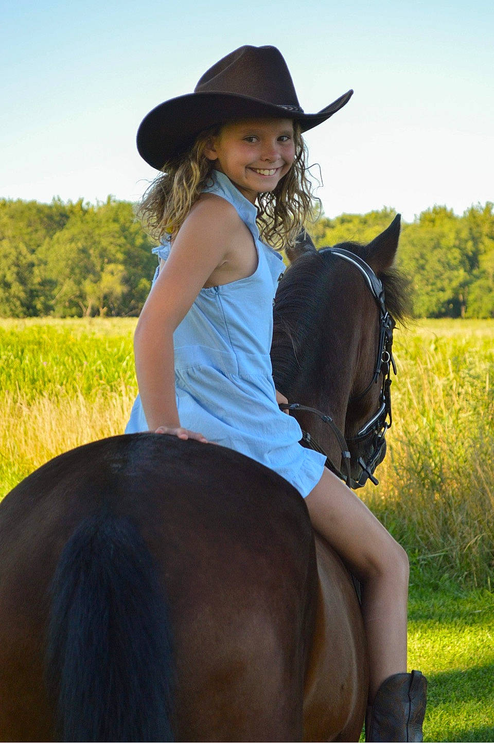Teagan is registered to the contest to win money with this photo: bridle, dress, ecoregion, equestrianism, grass, hat, headgear, headwear, horse, horse_supplies, horse_tack, joy, mammal, neck, person, photograph, plant, saddle, sky, sun_hat