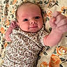 Dakota joined the competition — help win amazing prizes! baby, child, infant, portrait, smiling, lying_down, floral_blanket, floral_pattern, baby_clothing, onesie, fist, hand, face, eyes, indoor, close_up, adorable, happy, textile, photography