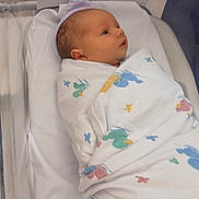 Dakota is registered to the contest to win money with this photo: newborn, baby, infant, hospital, bassinet, swaddled, blanket, cap, portrait, face, eyes_open, lying_down, nursery, medical_equipment, hospital_room, white_blanket, striped_hat, cozy, infant_care, photograph