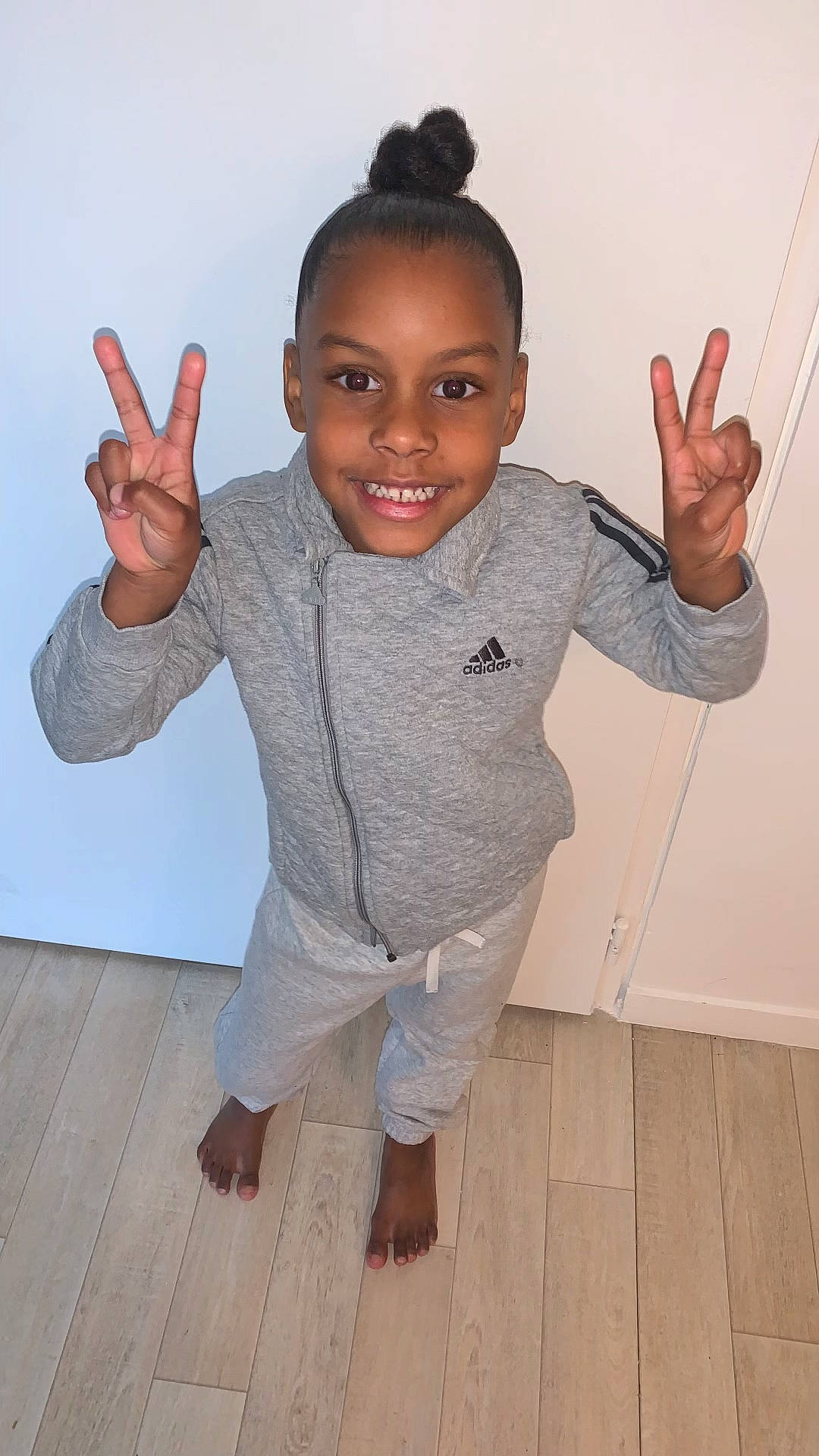 Ceyana a rejoint le concours — aidez-le/la à gagner de superbes lots ! arm, baby_toddler_clothing, cheek, elbow, finger, flash_photography, floor, flooring, gesture, hand, happy, hardwood, human_body, joint, joy, person, sleeve, smile, standing, thumb