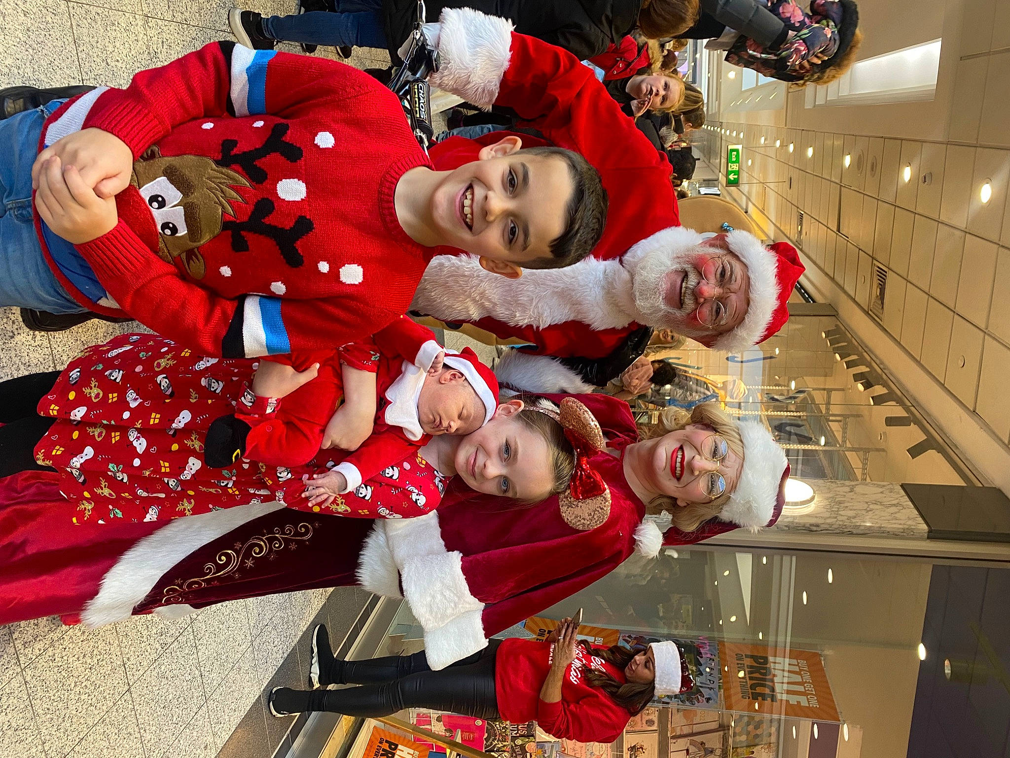 Zak is registered to the contest to win money with this photo: child, christmas, christmas_decoration, christmas_eve, christmas_ornament, event, fictional_character, fun, happy, headwear, holiday, human_body, joy, lap, person, plant, red, santa_claus, smile, toddler