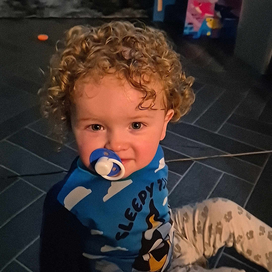 Carter-James is registered to the contest to win money with this photo: applique, baby, bodypart, clothing, crawling, face, finger, hand, head, indoors, knitwear, longsleeve, pants, pattern, person, photography, portrait, sitting, sweater, vest