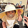 Adina joined the competition — help win amazing prizes! baby, pacifier, hat, hand, adult_hand, store, shelf, shoes, accessories, clothing, infant, person, indoor, shopping, curious, holding, cute, child, face, portrait