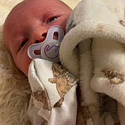 Marliya is registered to the contest to win money with this photo: baby, blanket, child, clothing, comfort, cozy, cute, face, head, indoor, infant, lying_down, newborn, pacifier, portrait, rug, sleepy, soft_texture, teddy_bear_print, warm