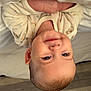 baby, child, infant, smiling, face, head, onesie, clothing, bed, blanket, floor, wooden_floor, indoors, cute, young, portrait, skin, happy, newborn, cozy