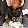 baby, sleeping, car_seat, infant, knitwear, white_socks, child, seatbelt, straps, peaceful, cute, newborn, indoors, resting, small_hands, soft_texture, head_support, comfort, portrait, closeup