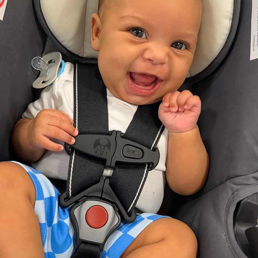 Jakobee joined the competition — help win amazing prizes! baby, car_seat, smiling, child, infant, blue_shorts, white_socks, pacifier, harness, happy, cute, indoor, seat, safety, portrait, person, clothing, baby_boy, expression, headrest